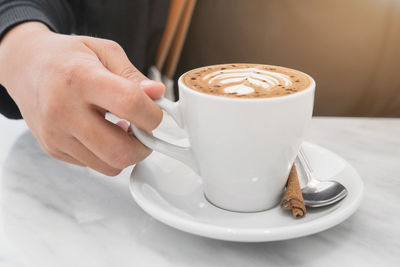 Midsection of coffee cup on table