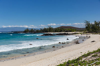 Scenic view of beach against blue sky