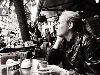 Thoughtful woman sitting at sidewalk cafe