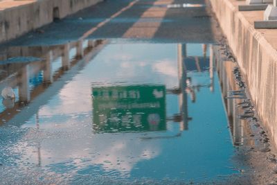 Reflection of building in puddle on street