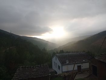 Houses on mountain against sky