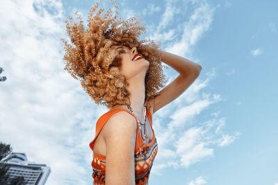 Low angle view of woman standing against sky