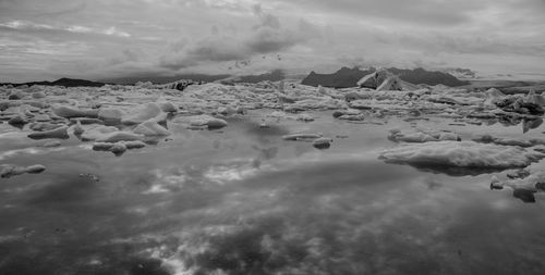 View of frozen lake against cloudy sky