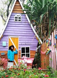 Full length of woman standing outside house