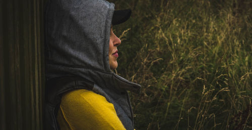 Profile view of woman standing against grass