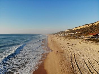 Scenic view of beach against clear blue sky