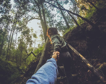 Low angle view of man on tree against sky