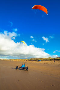 People on beach against sky