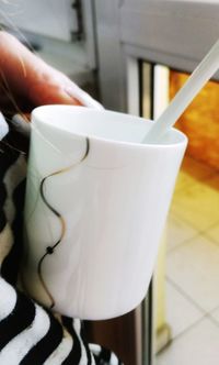 Close-up of hand holding coffee cup