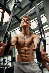 Shirtless muscular man exercising in gym