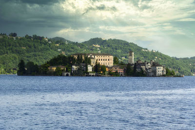 Scenic view of sea by buildings against sky