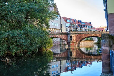 Arch bridge over river against sky