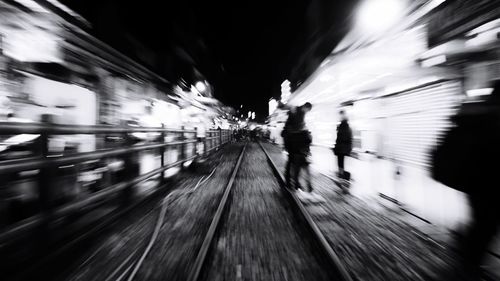 Blurred motion of people walking in illuminated tunnel