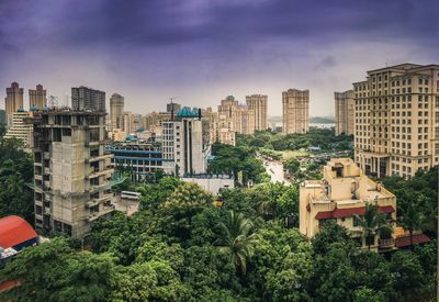 Trees and cityscape against sky