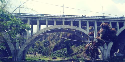 Arch bridge against sky in city