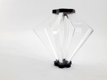 Low angle view of illuminated lighting equipment against white background