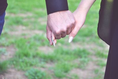 Low section of couple kissing on field