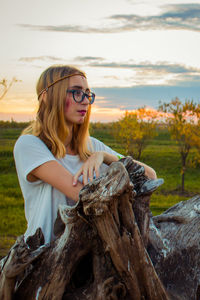 Young woman wearing mask on land against sky