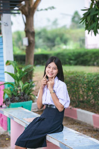 Girl touching cheeks while sitting on bench