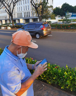 Man holding umbrella on street in city