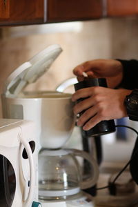 Midsection of man pouring coffee in cup