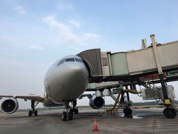 Airplane on airport runway against sky