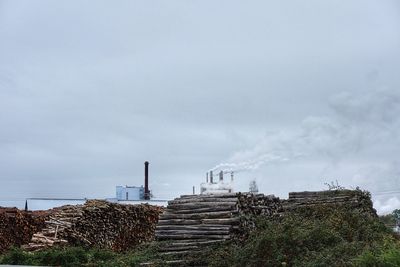 Factory emitting smoke against sky