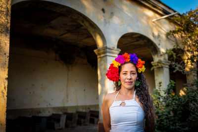 Portrait of woman standing against built structure