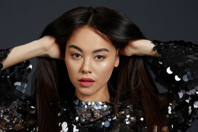 Close-up of young woman against black background