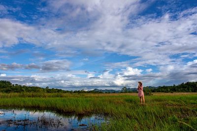 Woman standing on field against sky