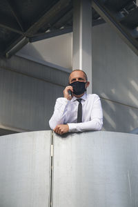 Portrait of man sitting on wall