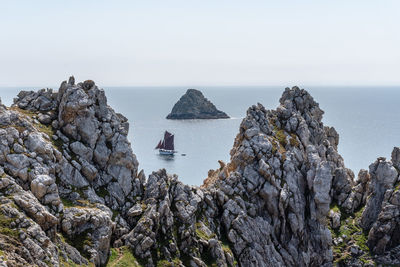 Scenic view of rocks in sea against sky