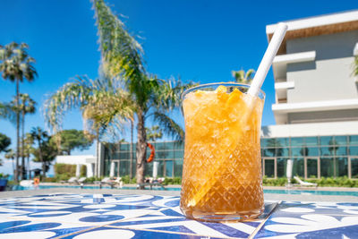 Fresh alcoholic cocktail with ice in glass on swimming pool. hard strong drink on sunlight 