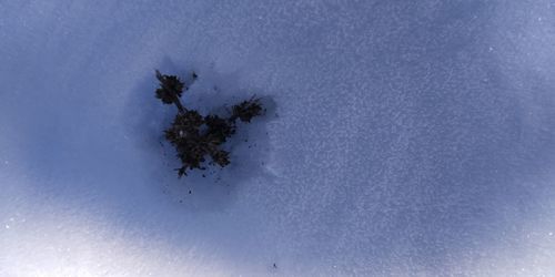 High angle view of snow covered land against blue sky