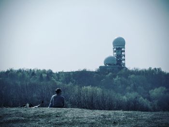 Rear view of man against trees against clear sky