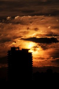 Silhouette of built structure against dramatic sky