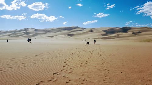 People on desert against blue sky