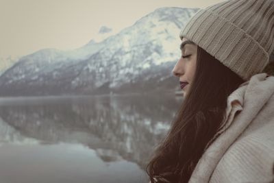 Side view of woman by lake during winter