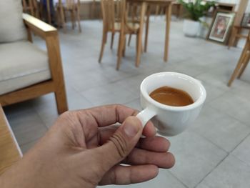 Cropped image of hand holding coffee cup