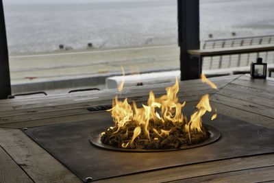 Close-up of fire on table against sea