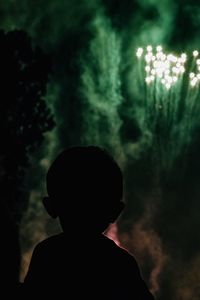 Rear view of silhouette boy standing at dusk