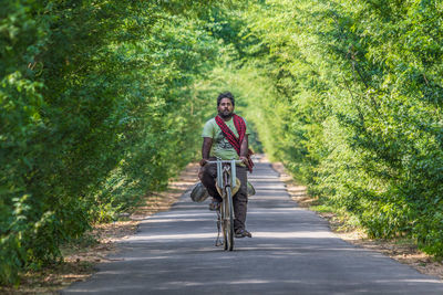 Portrait of man riding bicycle on road