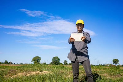 Man standing on field against blue sky