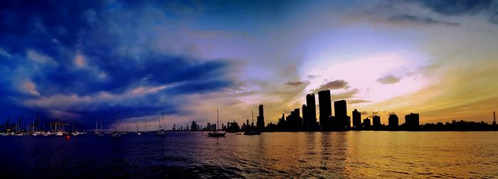 Panoramic view of sea and buildings against sky during sunset