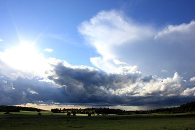 Scenic view of grassy field against cloudy sky