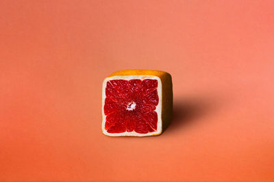 Close-up of strawberry against orange background