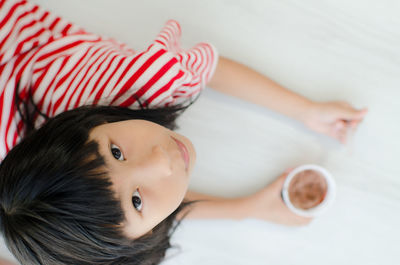 High angle portrait of girl having drink at home