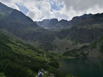 Scenic view of mountains and lake against cloudy sky