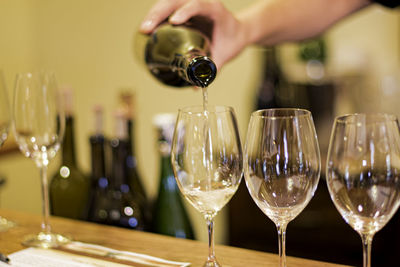 Midsection of person pouring wine in glass