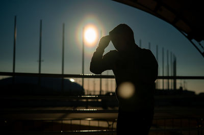 Low angle view of silhouette woman standing against sky during sunset